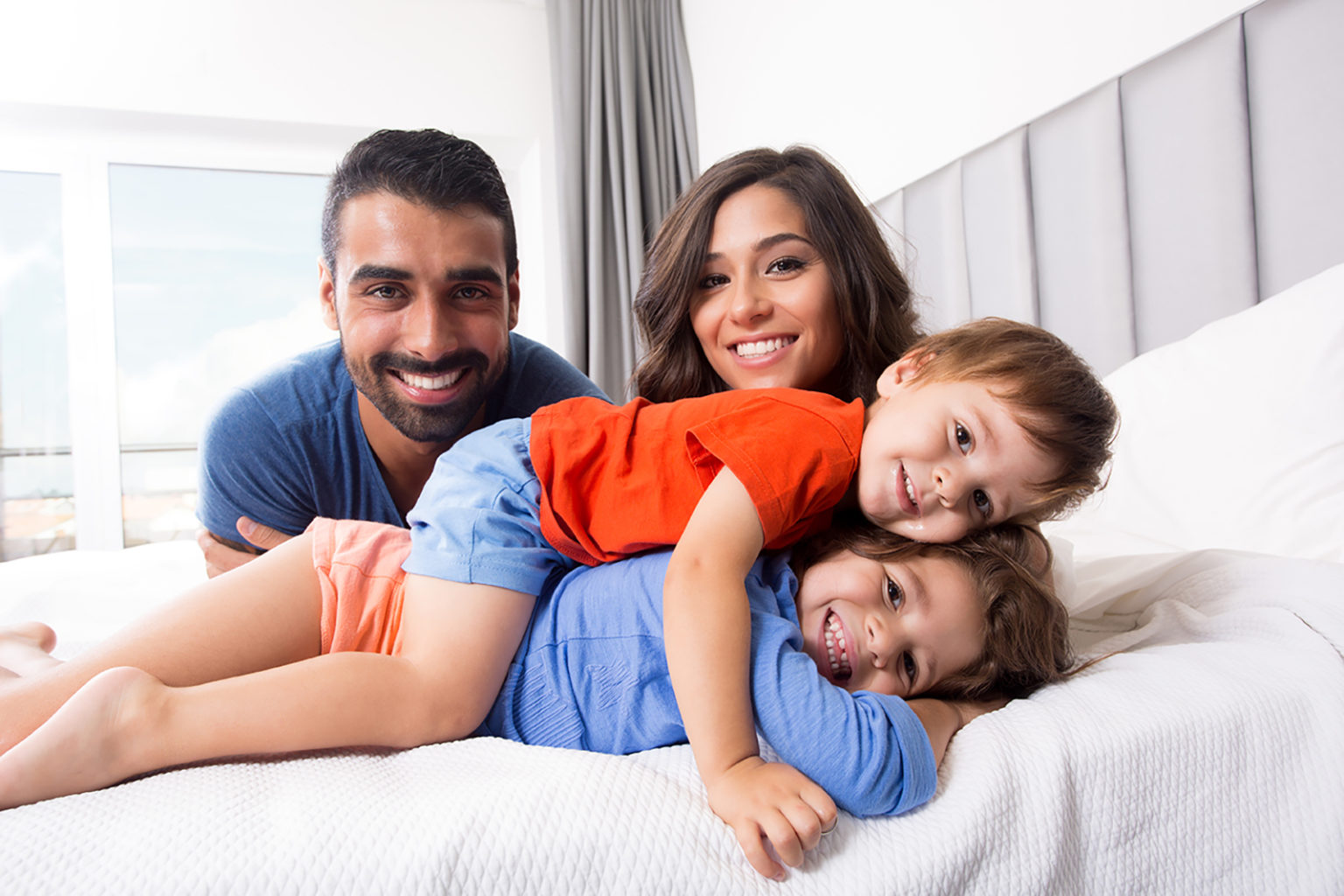 Happy family enjoying the morning in bed